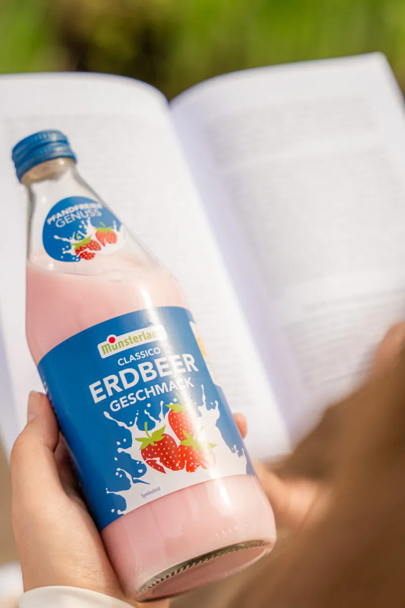 Münsterland Classico Erdbeere in der Glasflasche über einem aufgeschlagenen Buch