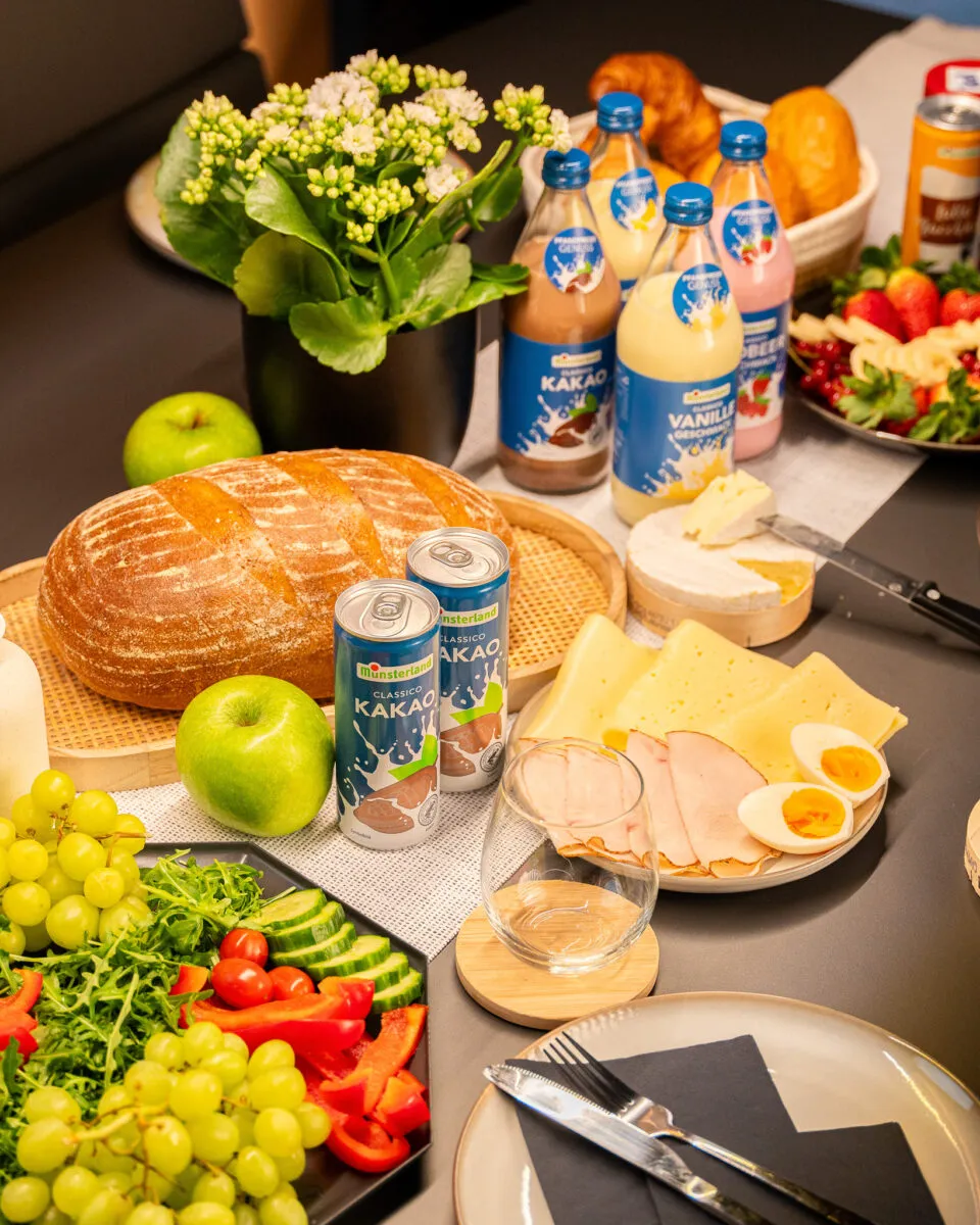 Gedeckter Tisch mit Brot, Käse, Obst und Münsterland CLASSICO Getränken